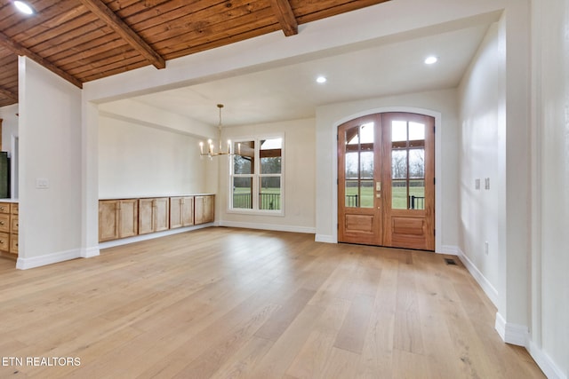 entryway with french doors, an inviting chandelier, lofted ceiling with beams, light hardwood / wood-style floors, and wood ceiling