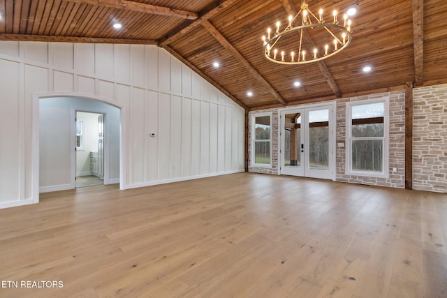 unfurnished living room featuring vaulted ceiling with beams, light hardwood / wood-style floors, a notable chandelier, and wood ceiling