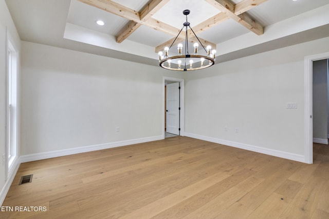 empty room featuring a chandelier, beam ceiling, light wood-type flooring, and coffered ceiling