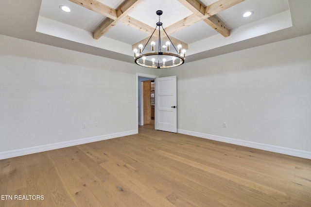 unfurnished room featuring coffered ceiling, beam ceiling, light wood-type flooring, and an inviting chandelier