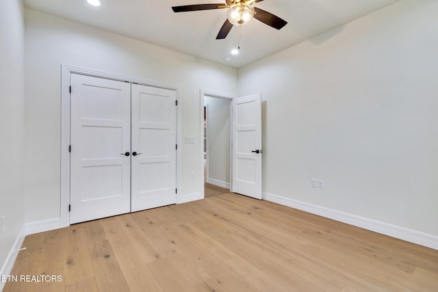 unfurnished bedroom featuring ceiling fan, a closet, and light hardwood / wood-style flooring