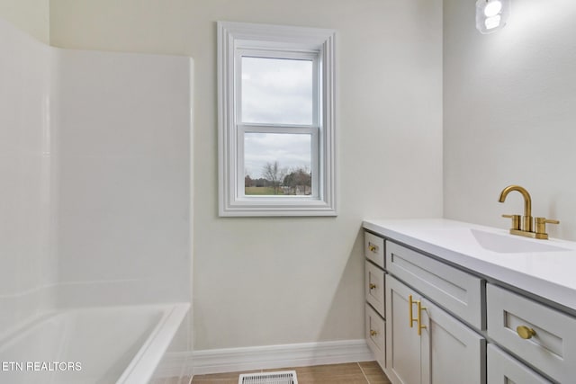 bathroom with a tub to relax in, vanity, and wood-type flooring