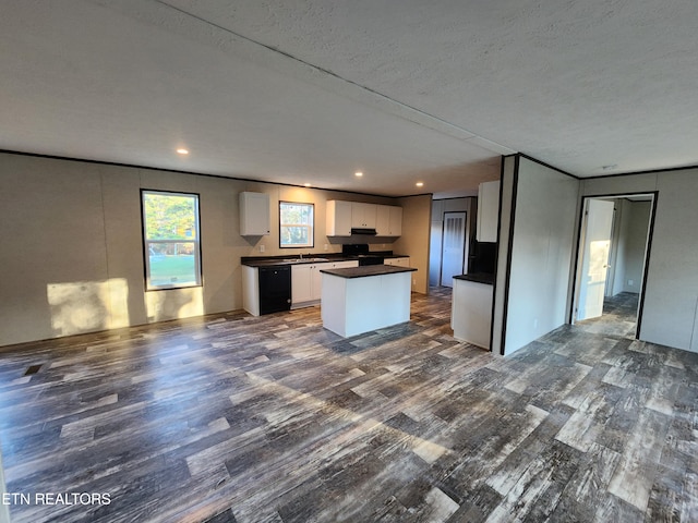 kitchen featuring a center island, sink, dark hardwood / wood-style floors, a textured ceiling, and white cabinets