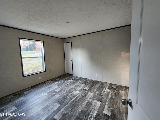 unfurnished room featuring wood-type flooring and a textured ceiling