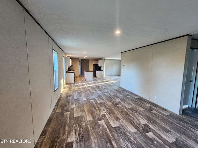 unfurnished living room featuring hardwood / wood-style floors and a textured ceiling