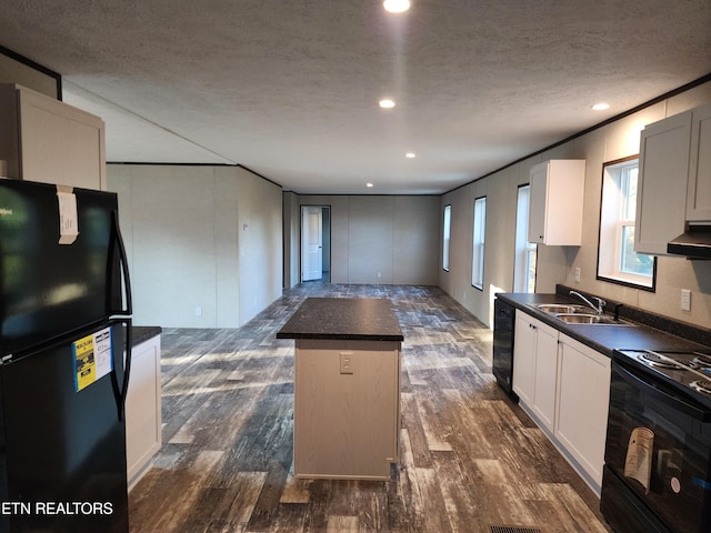 kitchen with a center island, sink, dark wood-type flooring, white cabinets, and black appliances