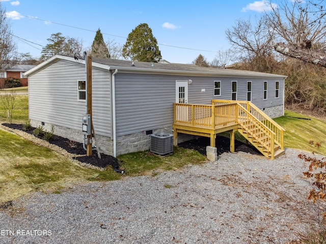 back of house featuring cooling unit, a lawn, and a wooden deck