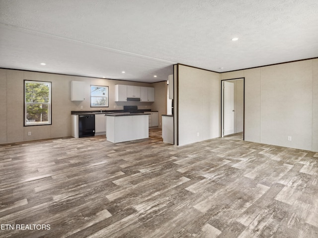 unfurnished living room featuring light hardwood / wood-style floors, crown molding, and a textured ceiling