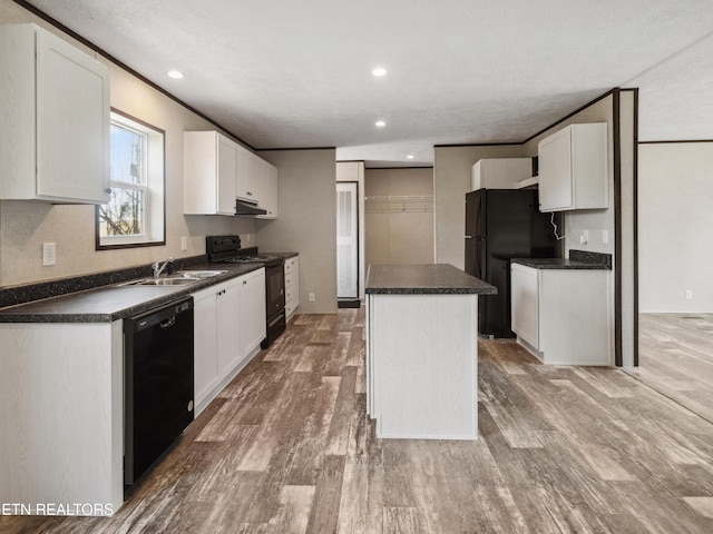 kitchen featuring white cabinetry, sink, black appliances, and a center island