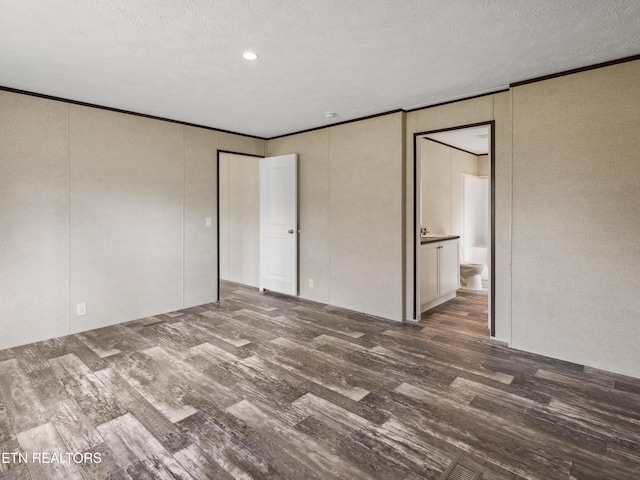 unfurnished bedroom with crown molding, dark hardwood / wood-style flooring, and a textured ceiling