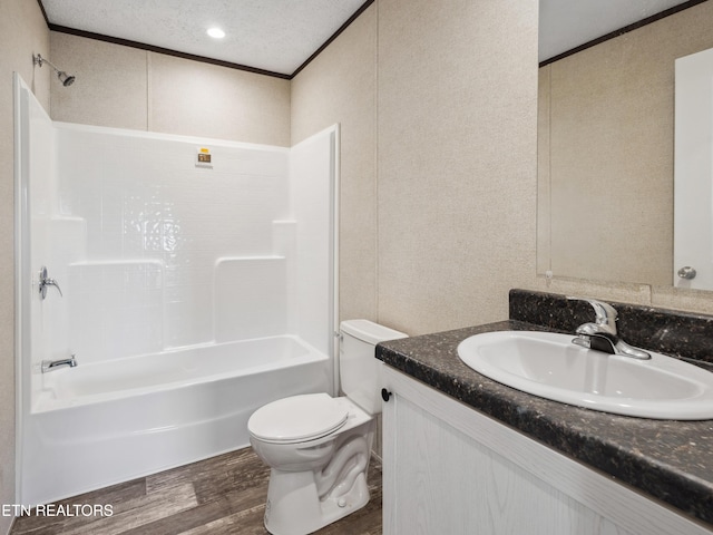 full bathroom with vanity, shower / washtub combination, a textured ceiling, toilet, and hardwood / wood-style flooring