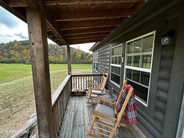 wooden terrace featuring a yard