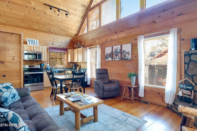 living room with track lighting, wood ceiling, high vaulted ceiling, light hardwood / wood-style floors, and wood walls