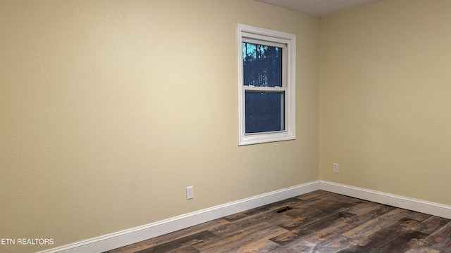 empty room with dark hardwood / wood-style flooring