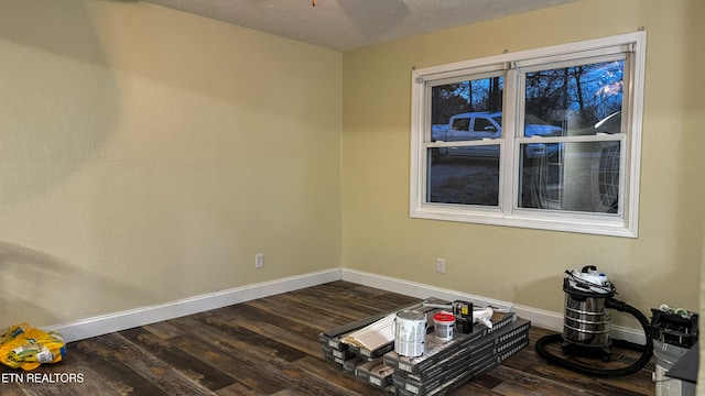 spare room featuring dark hardwood / wood-style floors and a textured ceiling