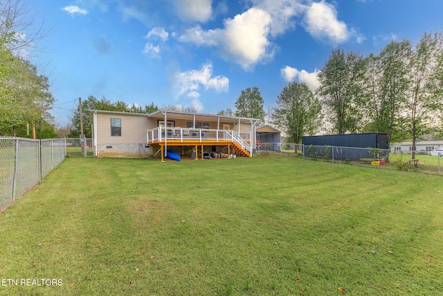 rear view of house featuring a lawn and a deck