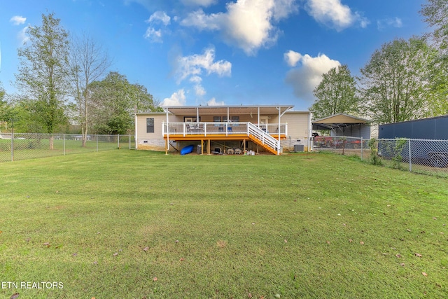 back of house featuring a wooden deck, a yard, and a carport