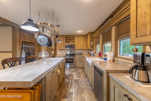 kitchen featuring hanging light fixtures, a breakfast bar area, dark hardwood / wood-style floors, a kitchen island, and stainless steel appliances