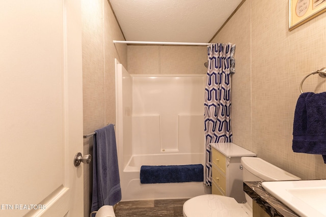 full bathroom featuring vanity, shower / bath combo, a textured ceiling, and toilet