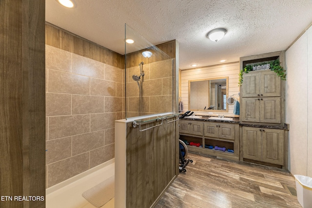 bathroom featuring hardwood / wood-style flooring, a textured ceiling, and walk in shower