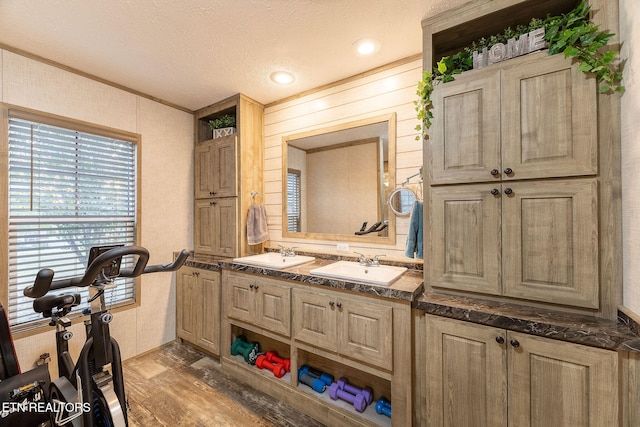 bathroom with vanity, wood-type flooring, a textured ceiling, and ornamental molding