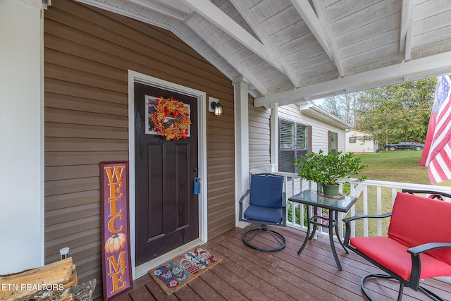 wooden terrace with a yard and covered porch