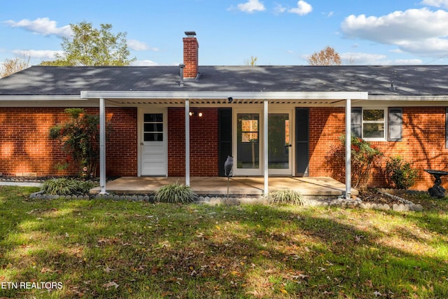 rear view of property featuring a yard and a patio