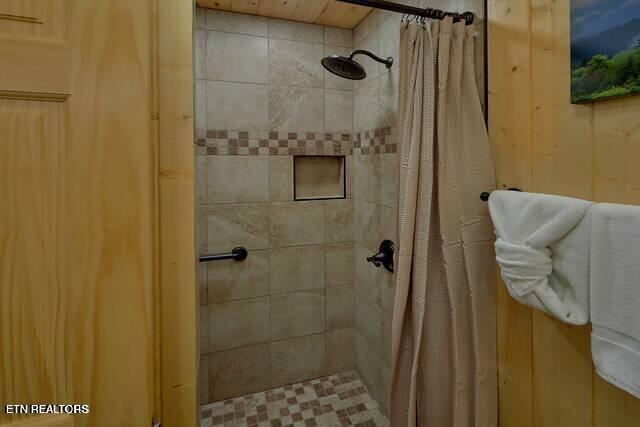 bathroom with walk in shower and wooden walls