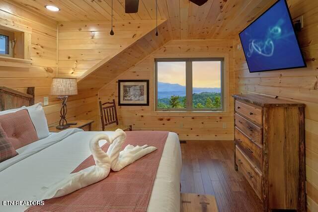 bedroom with wooden walls, wood ceiling, and hardwood / wood-style flooring