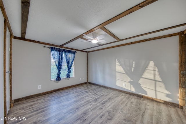 unfurnished room with beam ceiling, light wood-type flooring, and ceiling fan