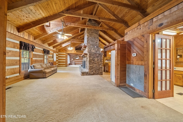 unfurnished living room featuring wood walls, light colored carpet, wood ceiling, and ornate columns