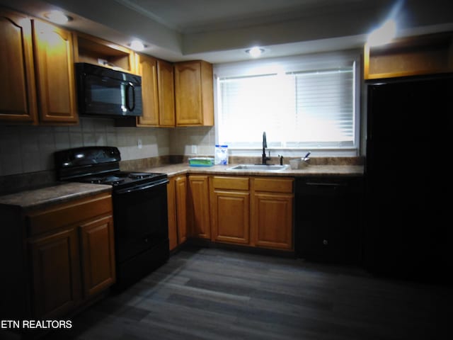 kitchen with black appliances, sink, dark hardwood / wood-style floors, ornamental molding, and tasteful backsplash