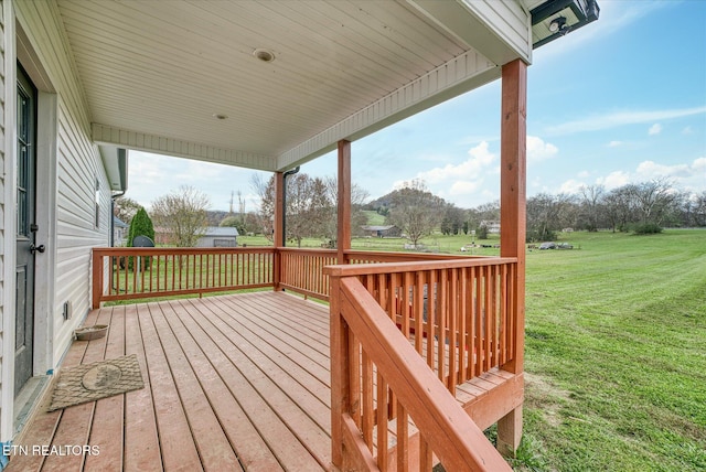 wooden terrace featuring a lawn