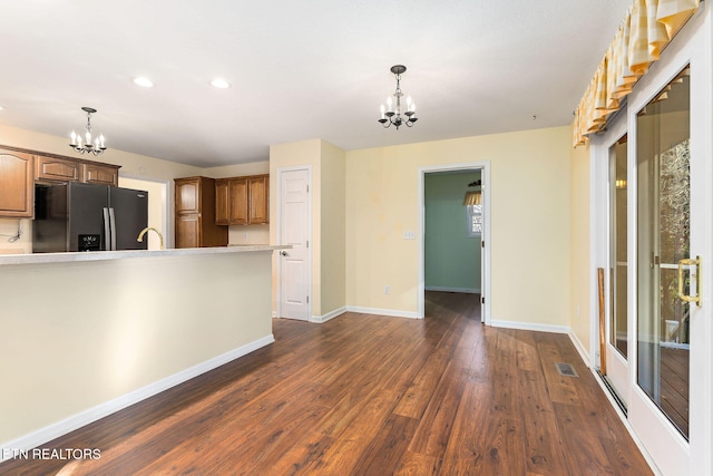 122 Windsor Rd, Crossville, TN 38558 - kitchen featuring black fridge with ice dispenser, an inviting chandelier, hanging light fixtures, and dark wood-type flooring