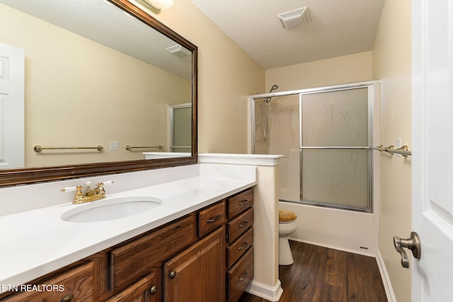122 Windsor Rd, Crossville, TN 38558 - full bathroom with hardwood / wood-style floors, vanity, shower / bath combination with glass door, toilet, and a textured ceiling