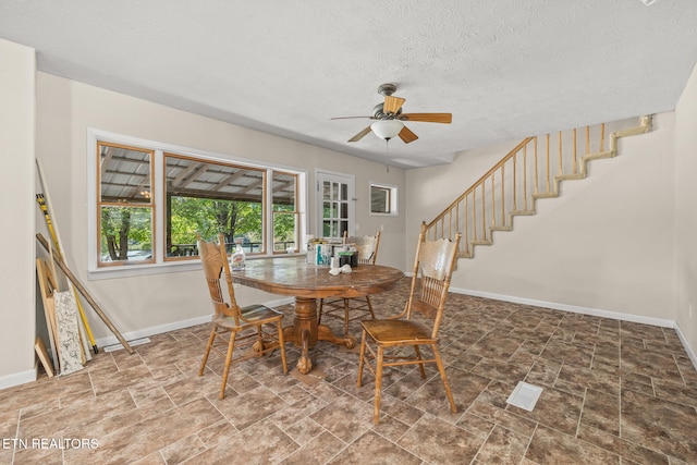 dining room featuring ceiling fan and a textured ceiling