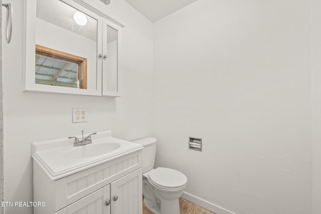 bathroom featuring tile patterned flooring, vanity, and toilet