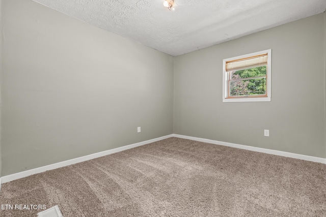 carpeted empty room with a textured ceiling