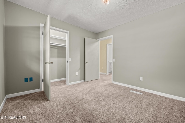 unfurnished bedroom with a textured ceiling and carpet floors