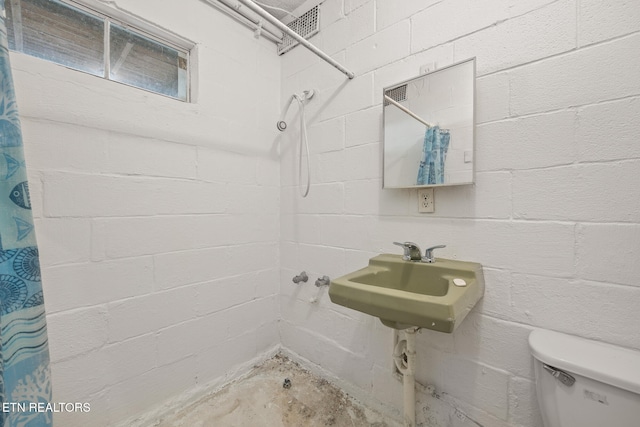 bathroom featuring curtained shower, sink, and toilet