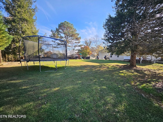 view of yard with a playground and a trampoline