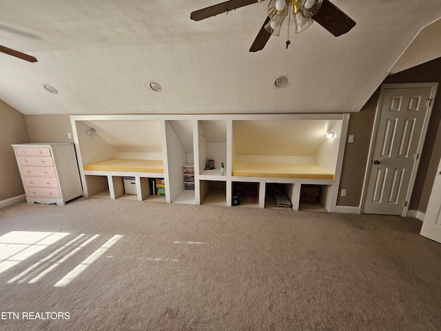 unfurnished bedroom with lofted ceiling, ceiling fan, carpet floors, and a textured ceiling