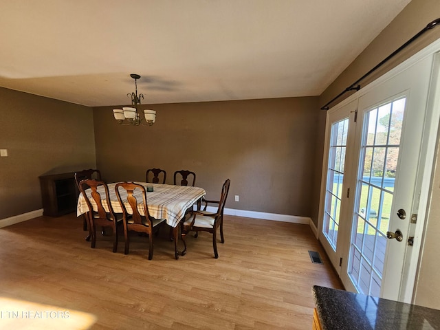 dining space with a chandelier and light hardwood / wood-style floors