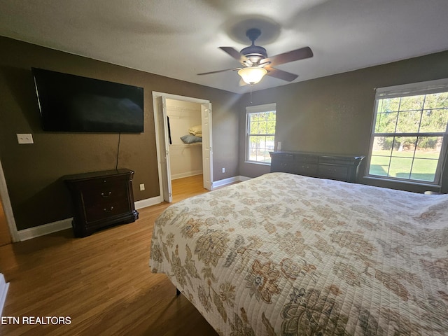 bedroom featuring ceiling fan, wood-type flooring, and ensuite bath