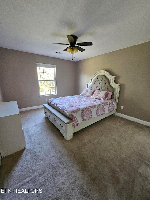 unfurnished bedroom featuring ceiling fan, a textured ceiling, and dark colored carpet