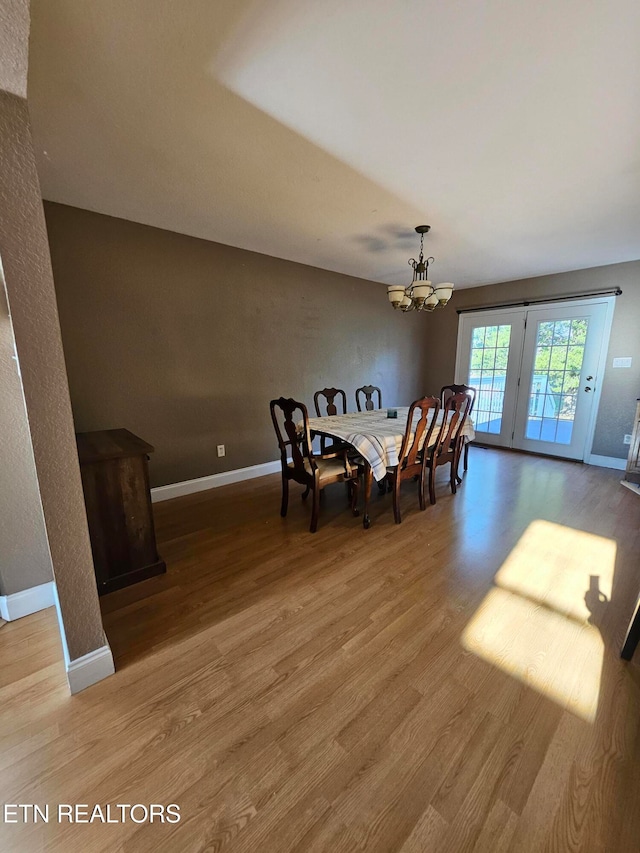 dining space with an inviting chandelier and hardwood / wood-style flooring