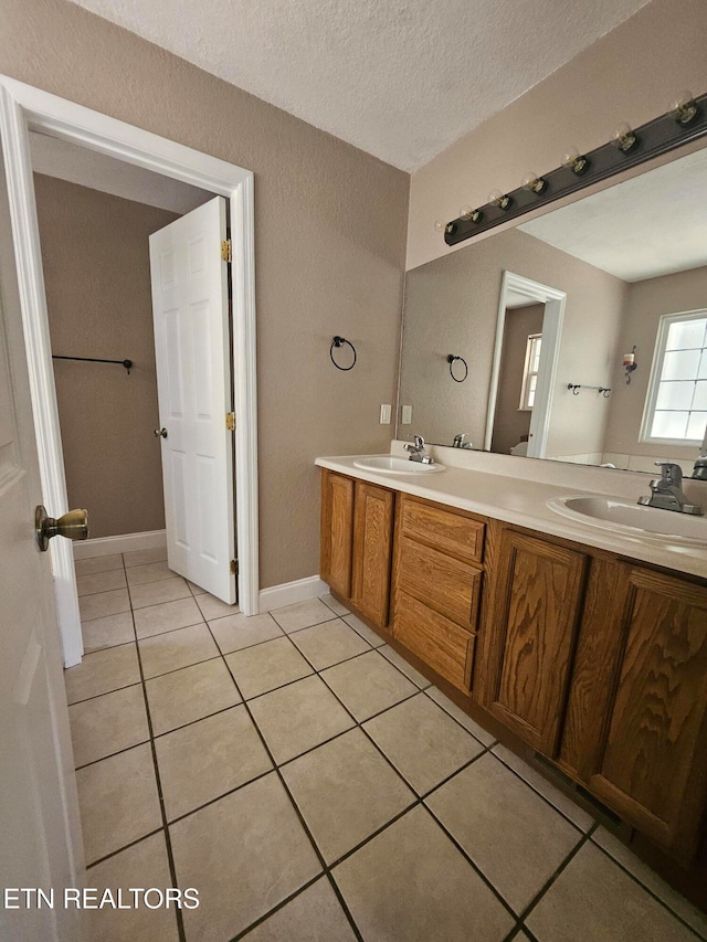 bathroom featuring tile patterned flooring, vanity, and a textured ceiling