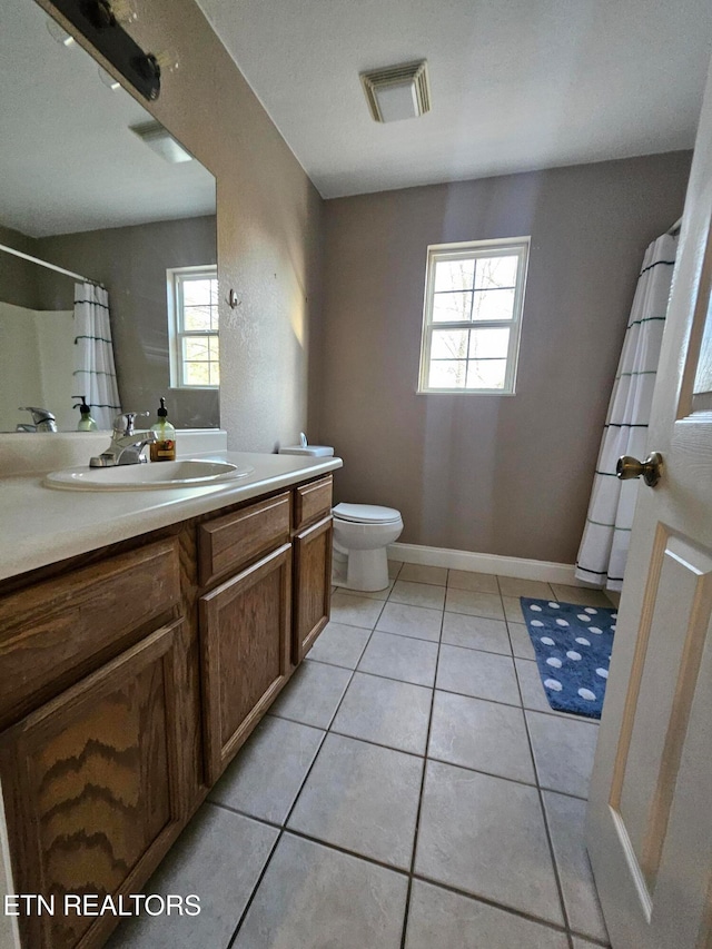 bathroom with toilet, vanity, and tile patterned floors