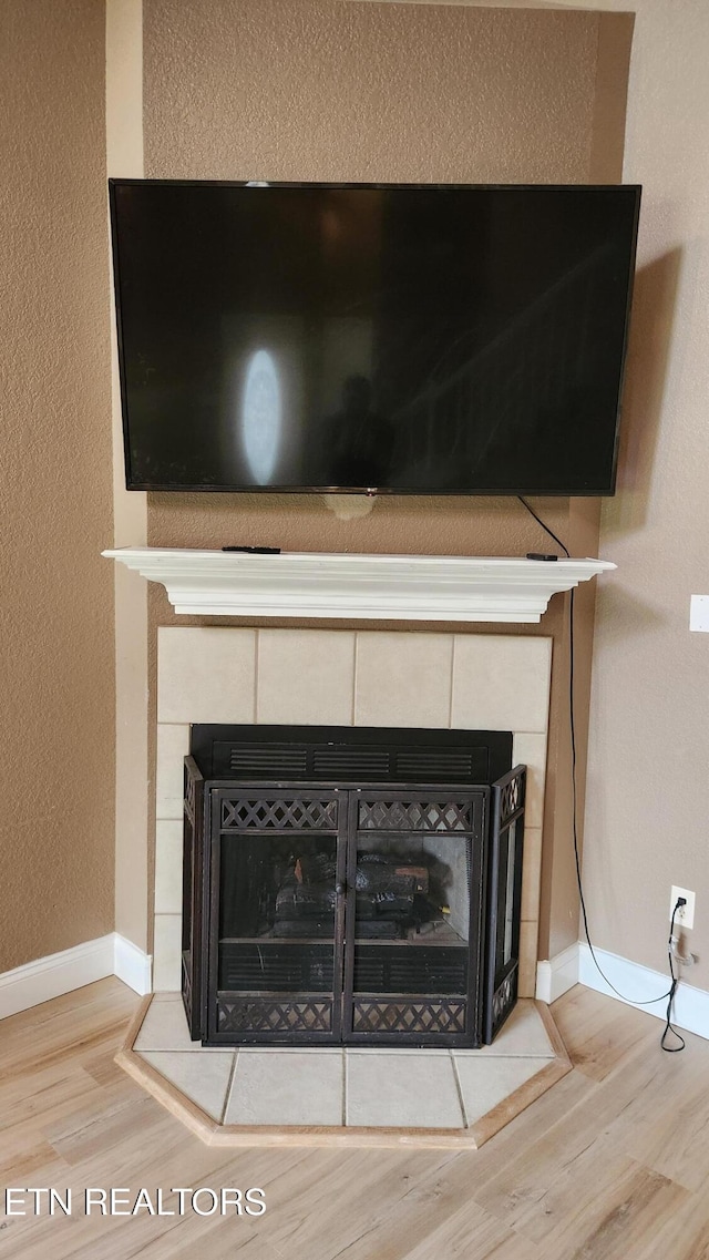 630 Chris Haven Dr, Seymour, TN 37865 - detailed view of wood finished floors, a tile fireplace, a textured wall, and baseboards