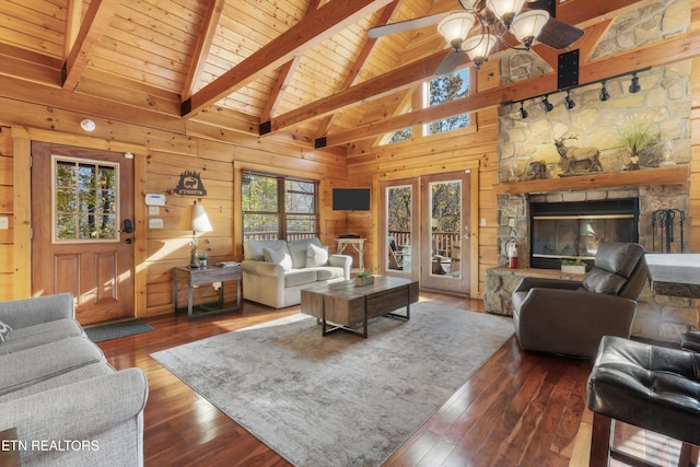 living room with a fireplace, high vaulted ceiling, dark wood-type flooring, and wood walls